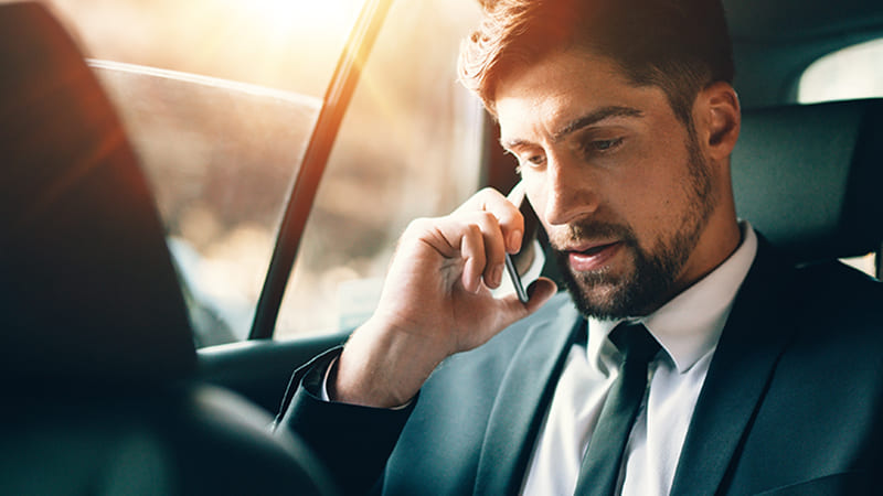 A man talking on the phone in a taxi