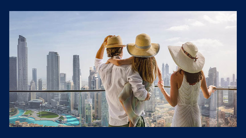 A family looking at Dubai city view from the balcony